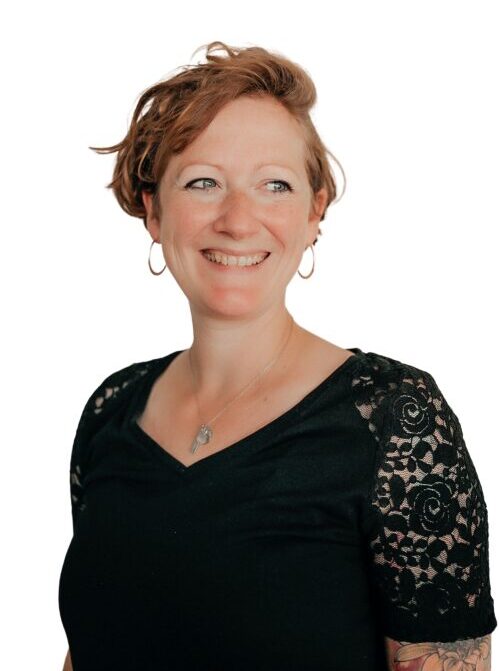 Henrike Schäfer mit schwarzem Shirt mit Spitze, Creolen, Kette von Liebeskind und Blick zur rechten Seite, lächelnd, Seitenscheitel auf der rechten Seite